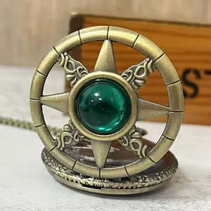 Detail of a vintage bronze quartz pocket watch with hollow star and green gemstone