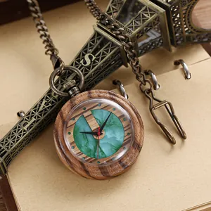 Nahaufnahme einer Vintage-Holz-Taschenuhr mit grünem Marmorzifferblatt und Kette.
