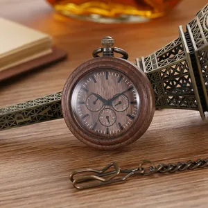 Nahaufnahme einer Vintage-Quarz-Taschenuhr aus Holz neben einem Eiffelturm-Modell.