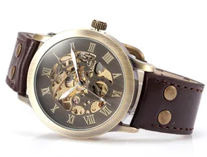 Detalle de reloj mecánico automático para hombre en bronce vintage con correa de cuero.