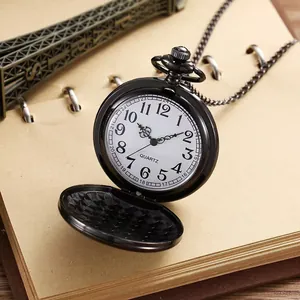 Close-up van een vintage zwart kwarts zakhorloge met open deksel op een notitieblok.