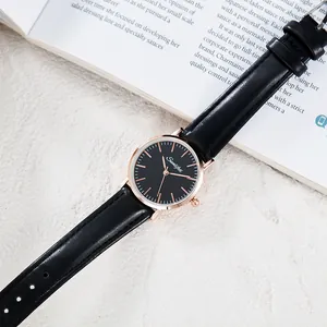 Detail view of a minimalist quartz watch with a black strap and rose gold case