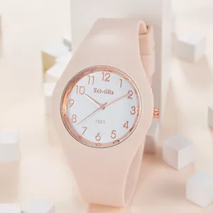 Primer plano de un elegante reloj de cuarzo para mujer con correa de silicona rosa y oro rosa.