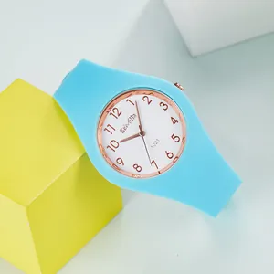 Detalle de cerca de un reloj de cuarzo de silicone azul brillante con esfera de oro rosa