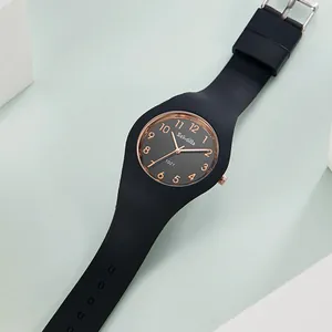 Detalle macro de un reloj de silicona negra minimalista con bisel en oro rosa