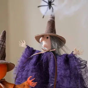 Close-up detail of a Halloween witch doll hanging ornament with purple mesh dress
