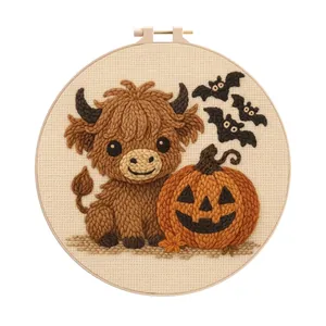 Detailed macro view of a Halloween embroidery kit featuring a cute highland cow and pumpkin