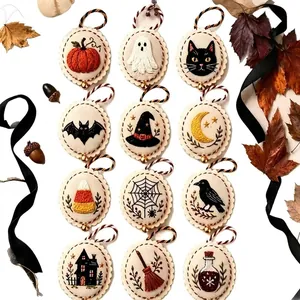 Nahaufnahme von zwölf verschiedenen Halloween Stickerei Ornamenten auf weißem Grund
