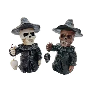 Detailed view of two different Halloween resin skeleton figurines in witch outfits