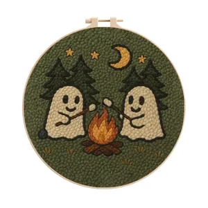 Detailed macro view of a Halloween ghost embroidery kit featuring ghosts and a campfire