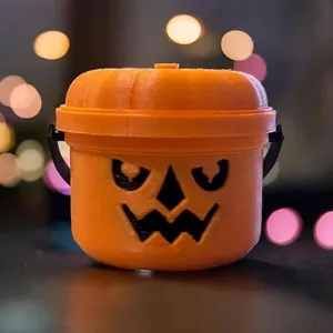 Close-up of an orange 3D-printed Spooky Mini Boo Bucket pumpkin figurine with a lid