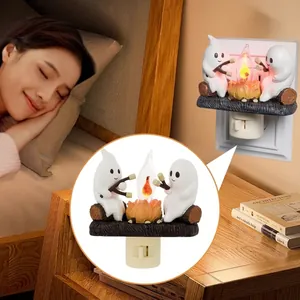 Detail showing a flickering ghost campfire night light plugged into a wall outlet