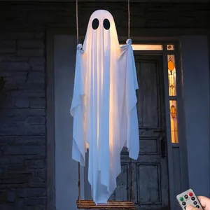 Large glowing white Halloween ghost decoration hanging on a swing for outdoor porch.