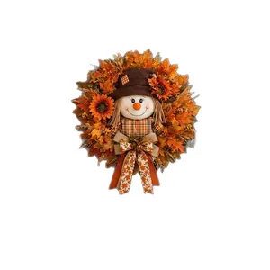 Ghirlanda autunnale spaventapasseri con foglie di acero e girasoli per decorazione