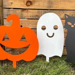 Close-up of Halloween ghost and pumpkin metal garden stakes on grass