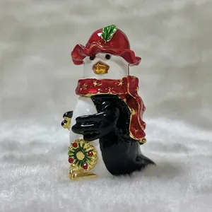 Vista macro detallada de un joyero de pingüino con sombrero y bufanda rojos y oro
