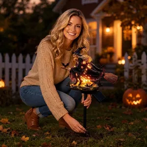 Detailed view of the glowing Halloween witch solar stake light in a garden setting