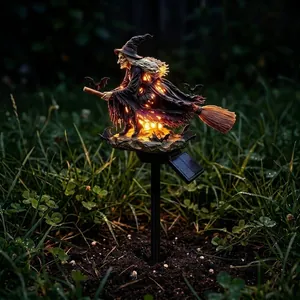 Detail of solar powered Halloween witch garden stake light illuminating at night