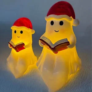 Par de luces nocturnas de fantasmas leyendo con gorros de Papá Noel para Navidad