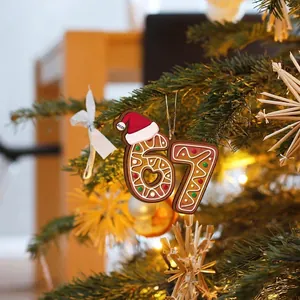 Festive 2025 Christmas gingerbread number 67 acrylic ornament hanging on a tree branch