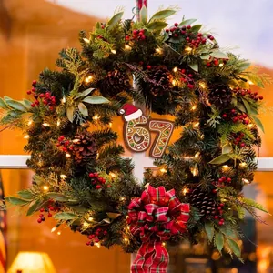 Gingerbread-style acrylic number 67 Christmas ornament hanging on a festive wreath.
