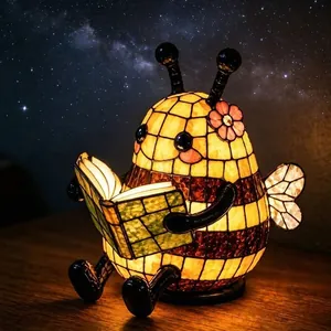 Lámpara de lectura de abeja en vidrieras que brilla sobre un fondo de cielo nocturno estrellado