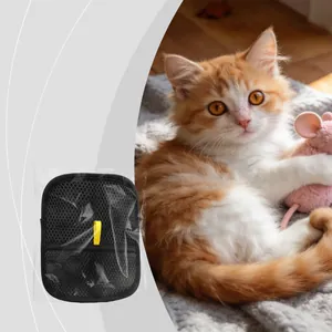 Zwarte ontharingshandschoen voor huisdieren naast een kitten voor het verwijderen van haar.
