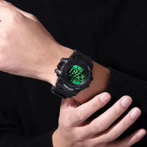 Close-up of a men's waterproof digital sports watch with a green backlit display on wrist