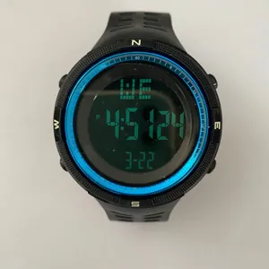 Macro detail of men's digital sports watch with negative green display and blue bezel