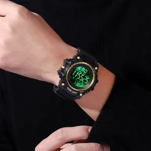 Close-up of a men's rugged black sports digital watch with green backlight on wrist.
