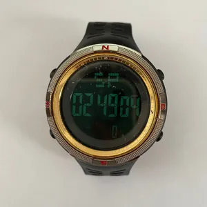 Detailed view of digital sports watch with green negative display and gold bezel