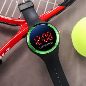 Detail view of a kids' green LED digital waterproof watch in a sporty setting with tennis gear.
