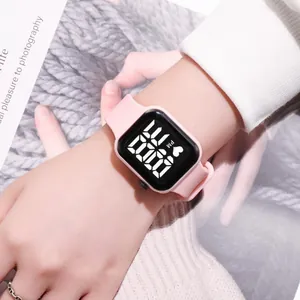 Detailed view of a stylish pink LED digital touch screen watch worn on a girl's wrist