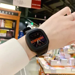 Detail view of a stylish black square quartz watch worn on a wrist in a library