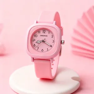 Makroansicht einer rosa minimalistischen Quarzuhr mit quadratischem Gehäuse und Silikonband