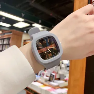Close-up of fashionable square quartz watch with a grey silicone strap worn on wrist