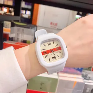 Modern white square quartz watch with minimalist red stripe dial worn on a female wrist