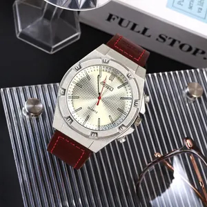 Macro vista di un orologio al quarzo vintage con quadrante crema e cinturino in pelle.