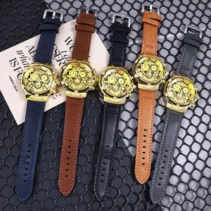 Detalle de cinco relojes de cuarzo para hombre con caja dorada y correas de cuero multicolor.