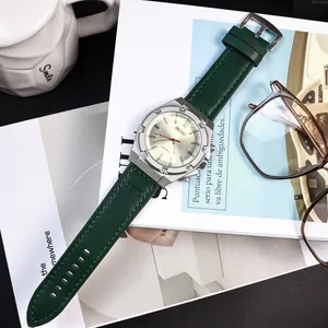 Primo piano di un orologio al quarzo retrò con cinturino in pelle verde e lancette luminose.