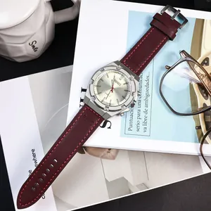 Primo piano di un orologio al quarzo vintage con cinturino in pelle bordeaux e quadrante