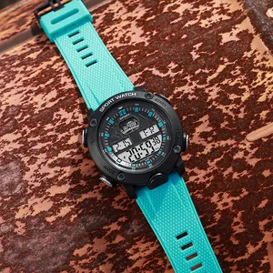 Detail view of a black sports digital watch with a bright cyan silicone strap on rusty metal.