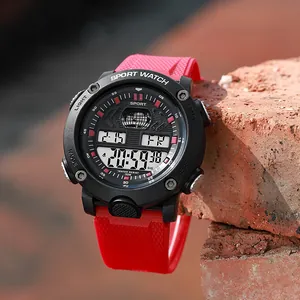 Close-up of red and black sport digital watch with waterproof dial on brick background
