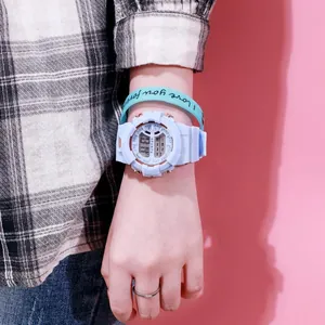 Detalle de reloj deportivo digital azul claro en la muñeca con pulsera a juego