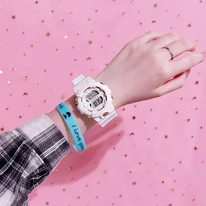 Vista detallada de un elegante reloj deportivo digital blanco con acentos dorados en la muñeca