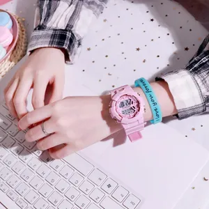 Primer plano de un elegante reloj deportivo digital rosa con correa de silicona en la muñeca.