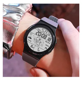 Primer plano de un reloj deportivo digital con diseño de astronauta y correa gris.