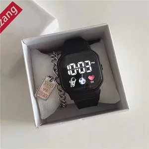 Close-up detail of a minimalist black digital watch and silver charm bracelet in white gift box