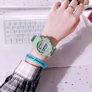 Detalle de un reloj deportivo electrónico impermeable verde menta en una muñeca