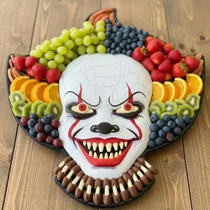 Halloween-Clown-Servierbrett gefüllt mit frischem Obst und festlichen Snacks